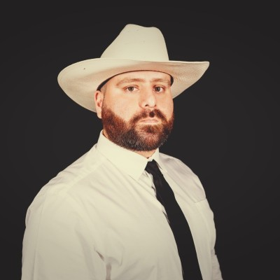 Cristian Estrada wearing a white cowboy hat, white shirt, and black tie